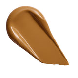 Revolution Conceal & Define Soft Matte Tube Foundation swatch in a rich, warm brown shade on a white background.