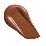 Revolution Conceal & Define Soft Matte Tube Foundation swatch in rich brown shade, showcasing smooth, full-coverage finish.