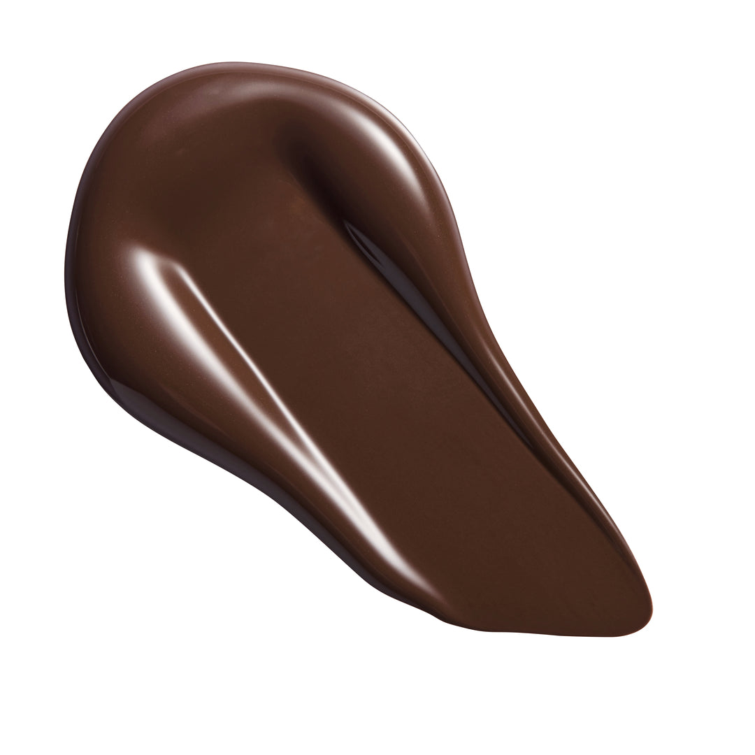 Revolution Conceal & Define Soft Matte Tube Foundation swatch of rich brown shade on a white background.
