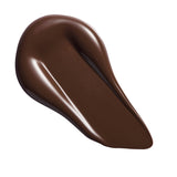 Revolution Conceal & Define Soft Matte Tube Foundation swatch of rich brown shade on a white background.