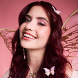 Revolution Fairy Drops Shimmer Topper Lilac Haze look on a model with butterfly accessories and a pink background.