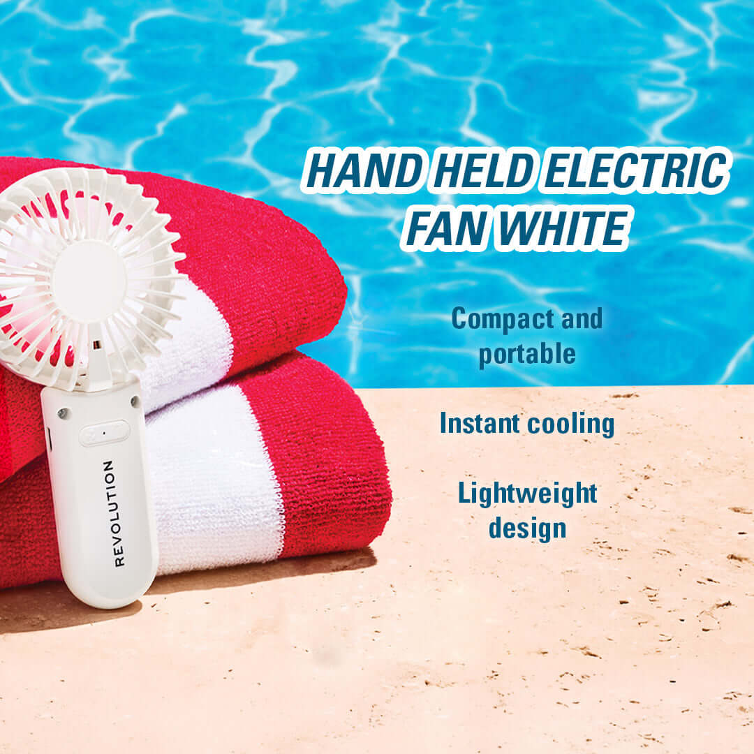 Revolution Poolside Hand Held Electric Fan White on towels by pool, lightweight and portable for instant cooling.
