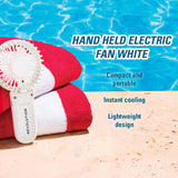 Revolution Poolside Hand Held Electric Fan White on towels by pool, lightweight and portable for instant cooling.