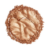Revolution Reloaded Highlighter in a shimmering bronze shade, showcasing its smooth, talc-free formula.