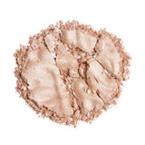 Revolution Reloaded Highlighter shimmering loose powder in a light tone, showcasing its smooth texture and luminous finish.