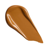 Swatch of Revolution Superfix Blur Longwear Foundation showing its smooth, creamy texture in a deep tan shade.