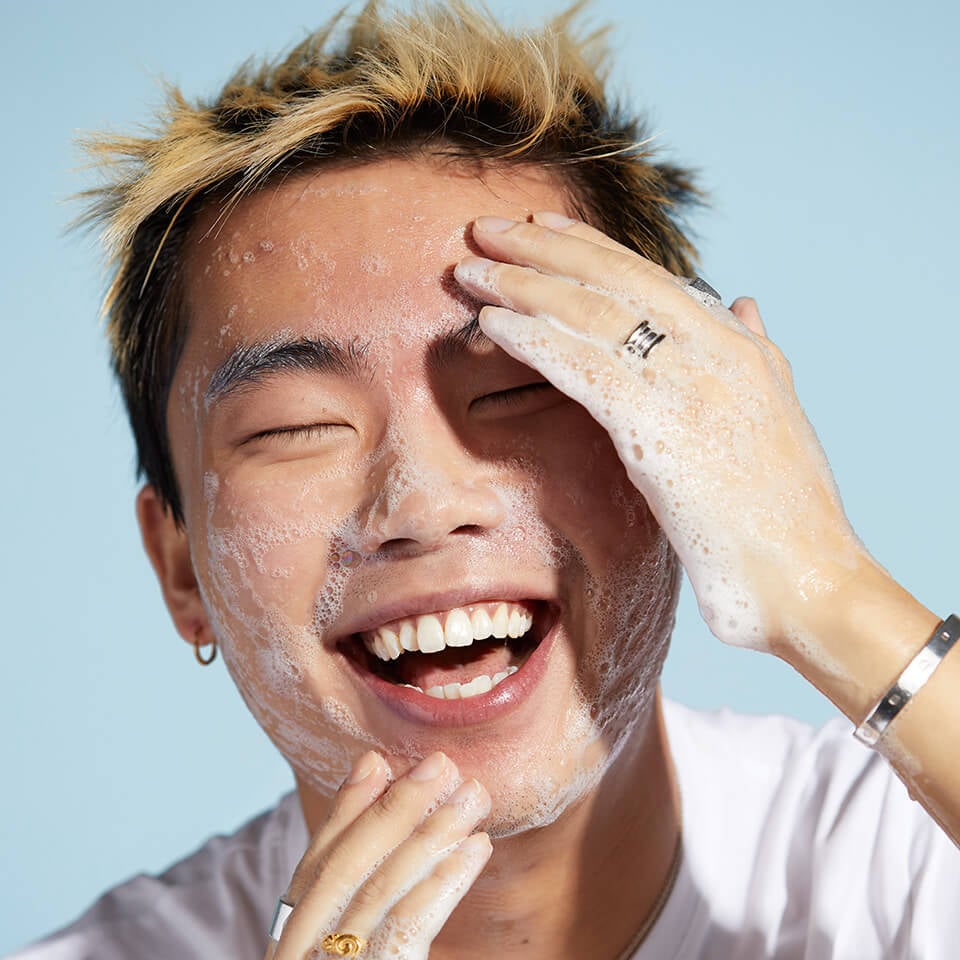 A photo of Kian applying the Revolution Skincare Ceramides Hydrating Cleanser