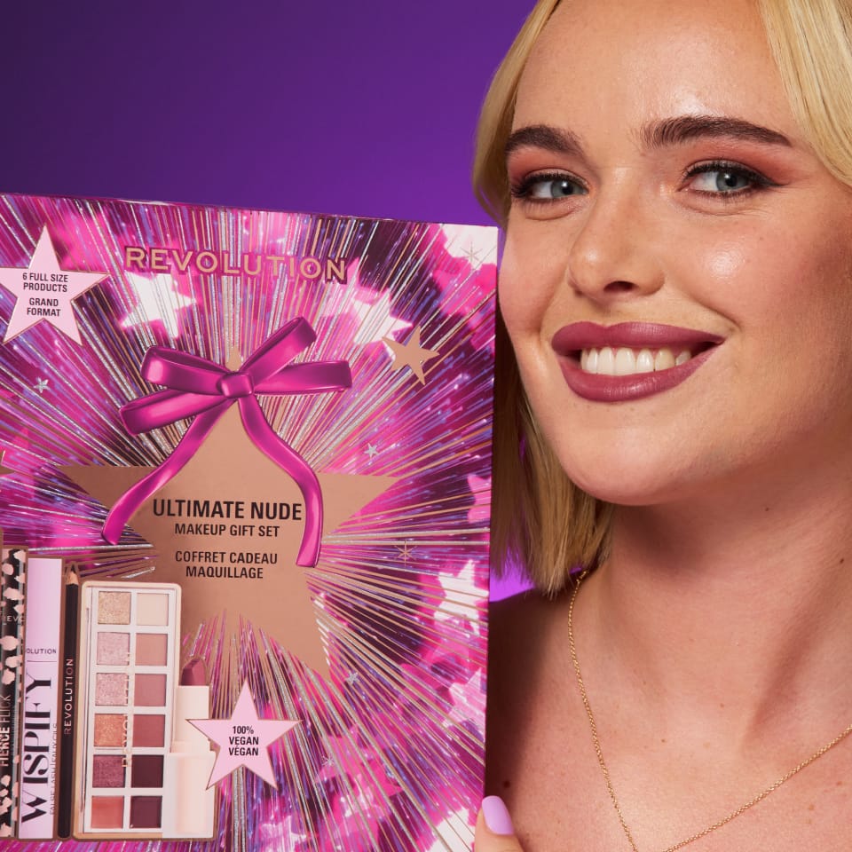 image of woman holding Revolution's Ultimate Nude Makeup Gift Set on a purple background