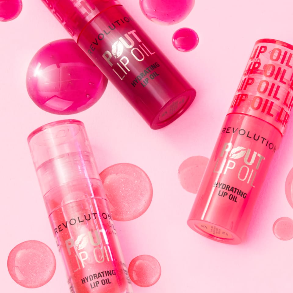 image of Revolution's Pout Lip Oil in three shades of pink on a light pink background